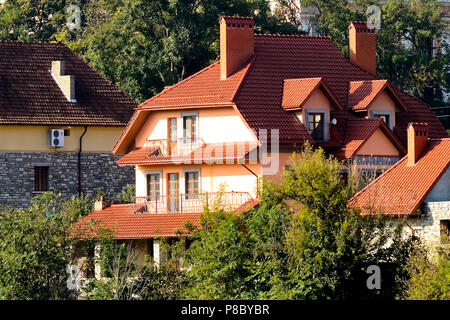 A due piani cottage con un attico e un tetto rosso Foto Stock