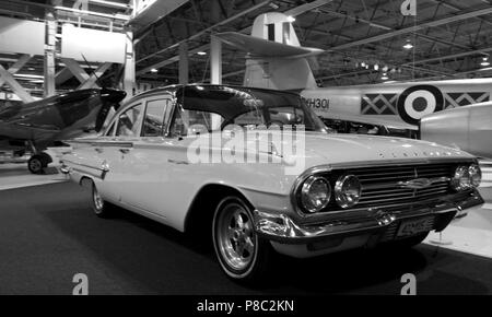 1960 Chevrolet Bel Air berlina, nella parte anteriore del Supermarine Spitfire XVI e Gloster Meteor F8, per Bonhams classico auto asta, RAF Museum di Londra, Regno Unito. Foto Stock