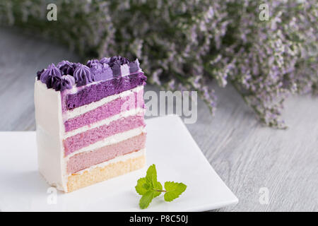 Torta ai mirtilli con fiore su legno.Copia dello spazio. Foto Stock