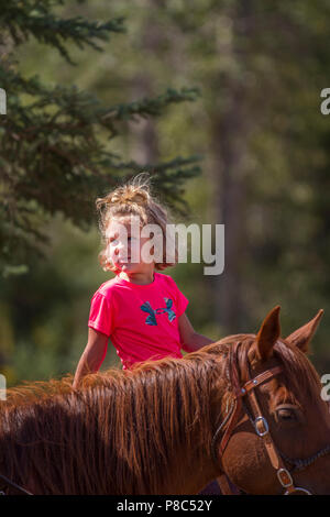 Giovani attraenti, bionda, ragazza, goig equitazione, seduta in sella. Modello di Rilascio #114 Foto Stock