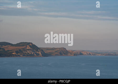 Lyme Regis, Dorset, Regno Unito. 10 luglio 2018. Tempo in Gran Bretagna: Una serata calda, ma leggermente più fresca sulla Costa Giurassica. Golden Cap e le splendide scogliere rocciose sulla Costa Jurassic sono immerse nel caldo e dorato bagliore del sole serale. Credit: PQ/Alamy Live News. Foto Stock