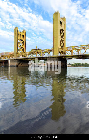 Il Tower Bridge con cielo wispy riflessa sul fiume Sacramento. Foto Stock