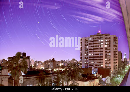 Notte stellata nella città. Sentieri delle stelle durante un'ora nello skyline del centro di citylife. Foto Stock