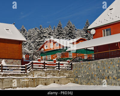 Diverse case di legno ricoperta di neve. Sullo sfondo vi è una foresta di pini . Per il vostro design Foto Stock