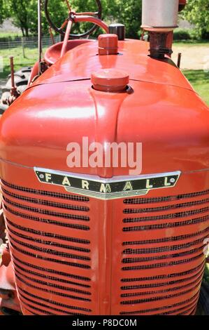 Ben mantenuta, rosso McCormick Farmall trattore parcheggiato su cascina in paesaggio rurale del Wisconsin, USA Foto Stock