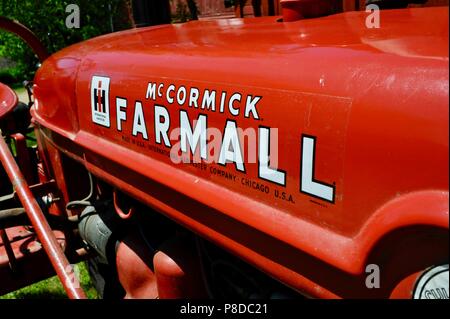 Ben mantenuta, rosso McCormick Farmall trattore parcheggiato su cascina in paesaggio rurale del Wisconsin, USA Foto Stock