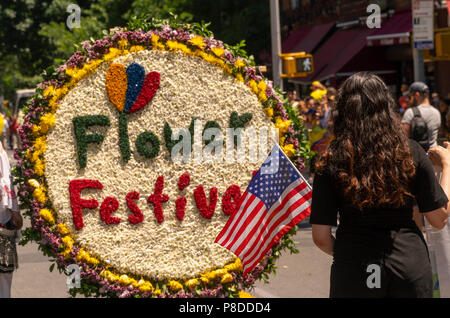 I partecipanti nel nono annuale parata dei fiori (Desfile de las Flores) in Jackson Heights quartiere di Queens a New York domenica 8 luglio 2018. La parata, completare con silleteros, fiore di venditori, portando medaglioni di fiori sulle loro spalle come silleteros che li portano sulle loro spalle giù per la montagna in Colombia intorno alla città di Medellin a vendere al mercato. Foto Stock