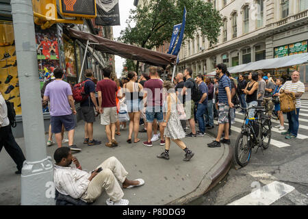 Entusiasta di gioco del calcio (calcio) tifosi guardare il Belgio batte il Brasile 2-1 a un ripiego "teatro" sul marciapiede esterno del Paragon negozio di articoli sportivi in Union Square a New York venerdì 6 luglio, 2018. (© Richard B. Levine) Foto Stock