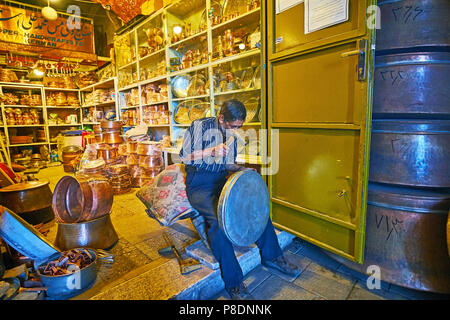 KERMAN, IRAN - 15 ottobre 2017: il ramaio all'ingresso in officina in Grand Bazaar produce il tegame grande, utilizzando un martello, il 15 ottobre ho Foto Stock