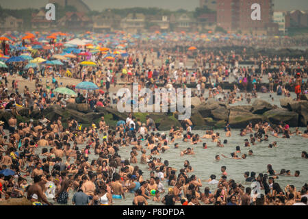 Migliaia di beachgoers prova a battere il calore opprimente e la fuga di Coney Island di Brooklyn a New York e letteralmente il pacco spiaggia domenica 1 luglio 1, 2018. La domenica è il giorno più caldo del 2018, raggiungendo sull'alta 90's tutta l'area, ma le temperature sono attesi a rimanere in 90's's tutta la settimana come un onda di calore si deposita sopra la città. (Â© Richard B. Levine) Foto Stock