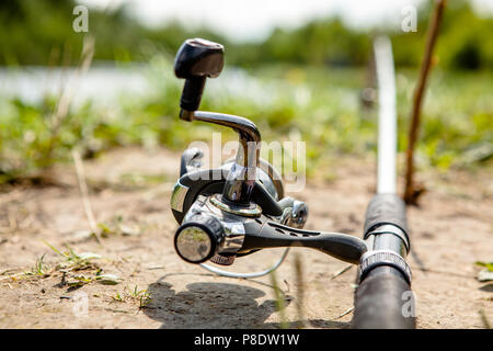 Fisherman's aspo, montato su una canna da pesca. La pesca dell'alimentatore in stile inglese. Foto Stock