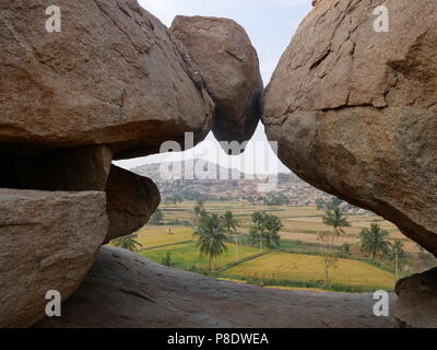 Risaie e giganteschi massi definiscono il paesaggio unico di Hampi ex capitale dell'antico Impero Vijaynagra in India è stato Karnataka. Foto Stock