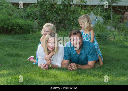 Estate portriat dei genitori e le sue due figlie, sulla posa di prato. Cranbrook, BC Canada. Modello rilasciato-dad #116, ragazza sulla sinistra #114 , ragazza di destra sul # Foto Stock