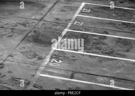 Ferry Terminal caricamento area portuale, la segnaletica stradale con numeri di corsia e linee divisorie su grigio sporco asfalto Foto Stock