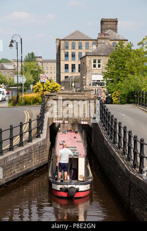 Narrowboat su The Huddersfield stretto canale passando attraverso il tunnel sotto la strada, Slaithwaite, West Yorkshire Foto Stock