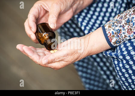 Pillole, la vecchiaia e il concetto di salute - pillole nelle mani di una vecchia signora closeup Foto Stock