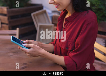 Donna Moderna controllo previsioni meteo sul suo smart phone Foto Stock