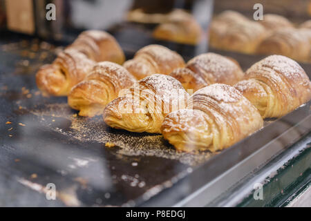 Molti di croissant. Pasticceria calda giacciono sul ripiano in cafe. Panini e bagel in negozio. Foto Stock