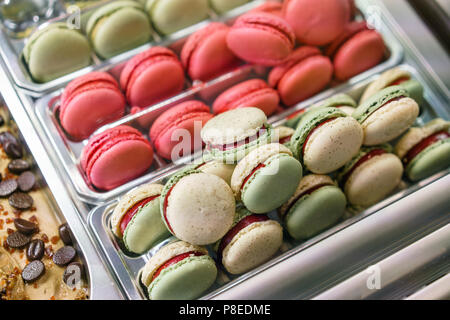 Assortimento di amaretti colorati su cafe vetrina. Varietà di sapori macaron. Dolce dolci di mandorla in negozio. Foto Stock