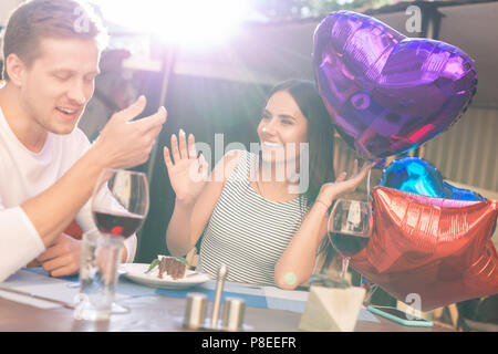 Buon compleanno donna seduta vicino a molti palloncini colorati Foto Stock