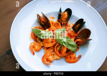 Gustosi piatti di pasta con gamberi e cozze in piedi sulla tavola Foto Stock