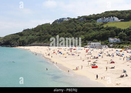 I vacanzieri e lucertole da mare sulla spiaggia di Newquay con mare azzurro. Newquay, Cornwall, Regno Unito Foto Stock