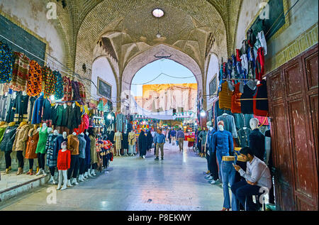 KERMAN, IRAN - 15 ottobre 2017: Grandi quantità di bancarelle di vestiti in vicolo di Sardar Bazar - uno dei numerosi dipartimenti della storica Grand Bazaar di Foto Stock