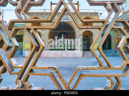 KERMAN, IRAN - 15 ottobre 2017: la vista sul portale di sicuro Hussainiya Azakhane attraverso la scenic stellar griglia di recinzione, il 15 ottobre in Kerman Foto Stock