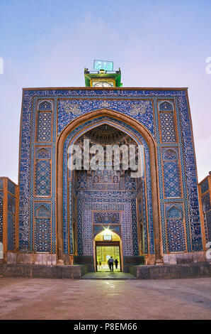 L'alto portale di ingresso di Jame Mozaffari moschea, rivolta verso Piazza Shohada, con la torre dell orologio sulla parte superiore, muqarnas decorazioni di arco e piastrelle ornate p Foto Stock