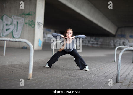 Femmina ballerino di strada di eseguire su un marciapiede. Lunghezza intera. Foto Stock