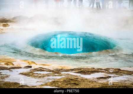 Geyser Strokkur durante la sua attività; questo geyser erutta un getto di acqua a circa trenta metri di altezza a intervalli irregolari di 3/5 minuti Foto Stock