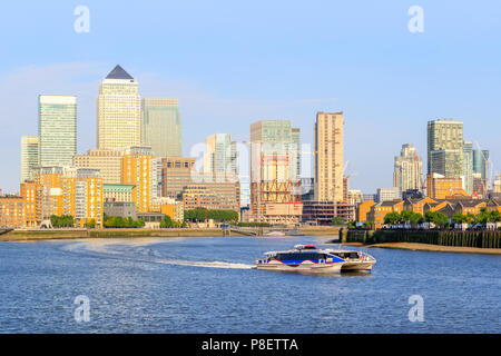 Una barca di crociera su Londra fiume Tamigi con Canary Wharf cityscape in background Foto Stock
