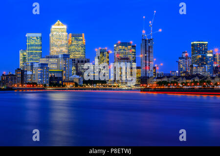 Una lunga esposizione, illuminato cityscape di Canary Wharf, un quartiere principale degli affari nella zona est di Londra Foto Stock