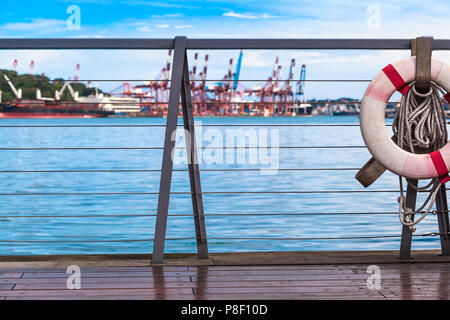 Vista dal molo in legno con ringhiera di sicurezza e di vita boa alla banchina del porto di Keelung, Taiwan Foto Stock