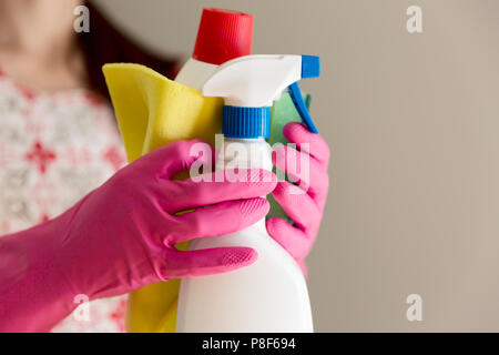 Giovane donna azienda gruppo di materiali per la pulizia. Apparecchi per uso domestico, pulizia di primavera, riordino, il servizio di pulizia concept Foto Stock