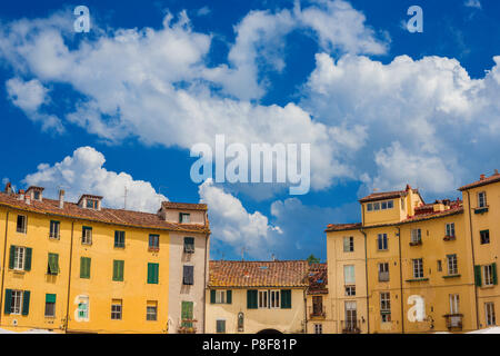 La famosa Piazza dell'Anfiteatro (Piazza Anfiteatro) nel centro storico di Lucca, con le case costruite sull'antica arena romana rovine Foto Stock