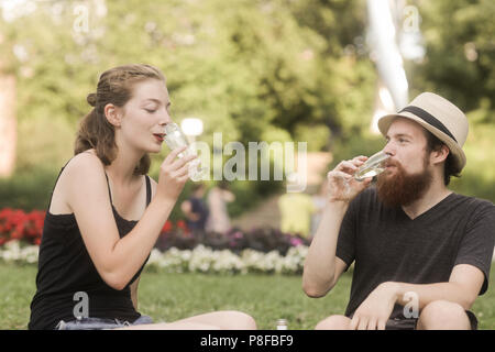 Coppia felice gustando un bicchiere di champagne nel parco Foto Stock