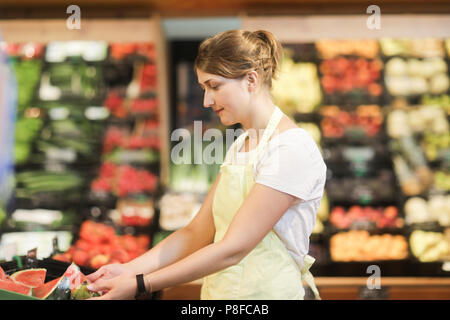 Assistente vendite lavorazione della frutta e della verdura sezione Foto Stock