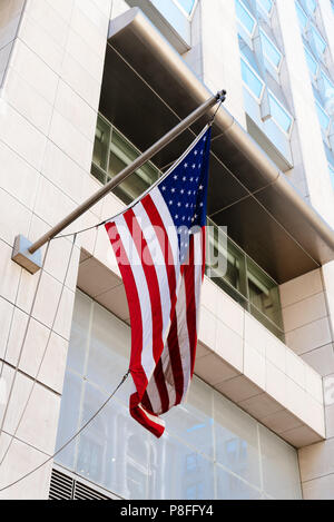 Bandiera americana agitando contro ufficio moderno edificio. Foto Stock