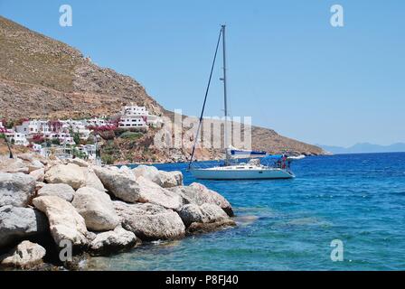 Uno yacht entra nel porto di Livadia sull'isola greca di Tilos il 12 giugno 2018. Foto Stock