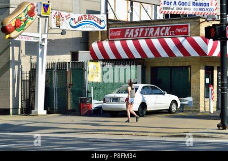 Chicago, Illinois, Stati Uniti d'America. Lone passeggiate pedonali lungo Lake Street e passato un locale nighborhood hot dog stand e cena. Foto Stock