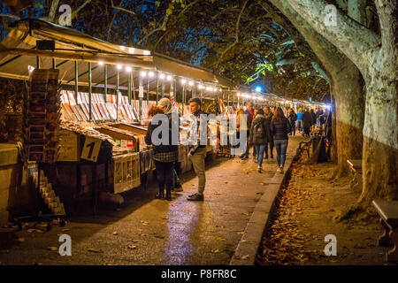 Piccoli negozi sul fiume Tevere nei pressi di Umberto I Bridge in una sera d'inverno, Roma, Italia. Foto Stock