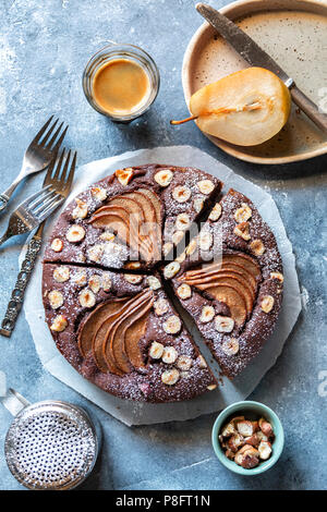 Torta al cioccolato con le pere e le nocciole sul tavolo Foto Stock