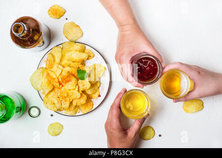 Tre Mani di tenere i vetri con un assortimento di birre. Foto Stock