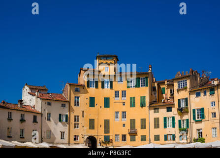 La famosa Piazza dell'Anfiteatro (Piazza Anfiteatro) nel centro storico di Lucca, con le case costruite sull'antica arena romana rovine Foto Stock