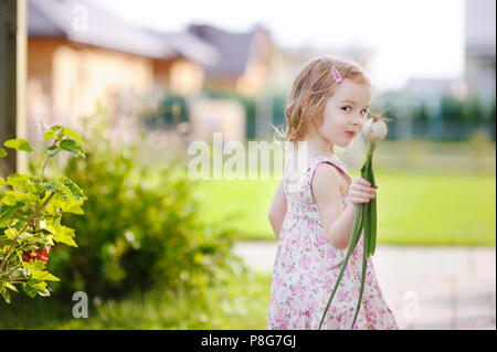 Adorabile bambina contribuendo in un giardino Foto Stock