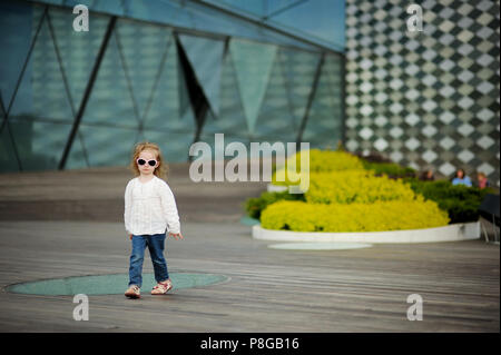 Adorabile bambina in occhiali da sole all'aperto Foto Stock