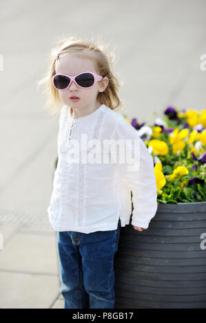 Adorabile bambina in occhiali da sole all'aperto Foto Stock