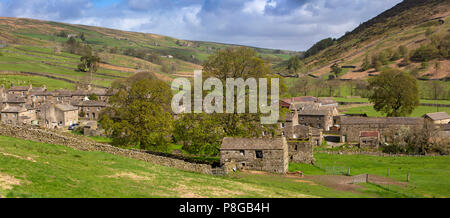 Regno Unito, Inghilterra, Yorkshire, Swaledale, Thwaite, case di villaggio fattorie e fienili di campo al di sotto di pendici della collina Kisdon, panoramica Foto Stock