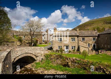 Regno Unito, Inghilterra, Yorkshire, Swaledale, Thwaite, case di villaggio attraverso ponte sopra la paglia Beck Foto Stock